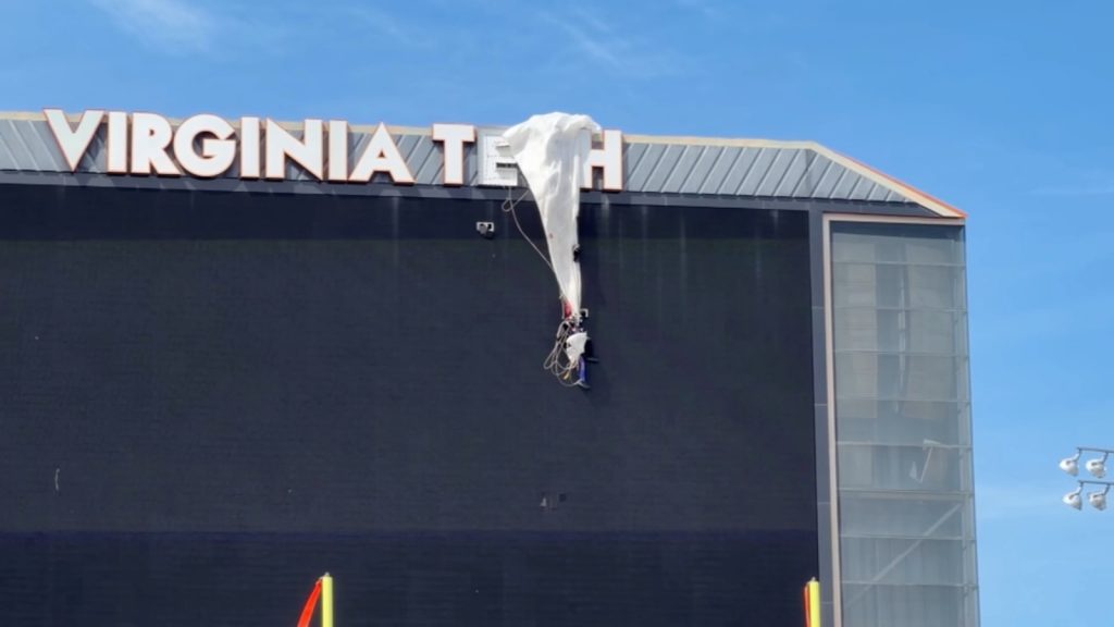 Video shows skydiver rescued after crashing into scoreboard, dangles from parachute at Virginia Tech spring football game